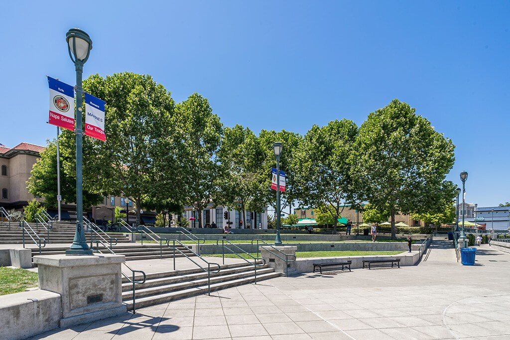 A park with benches and trees under a clear blue sky
